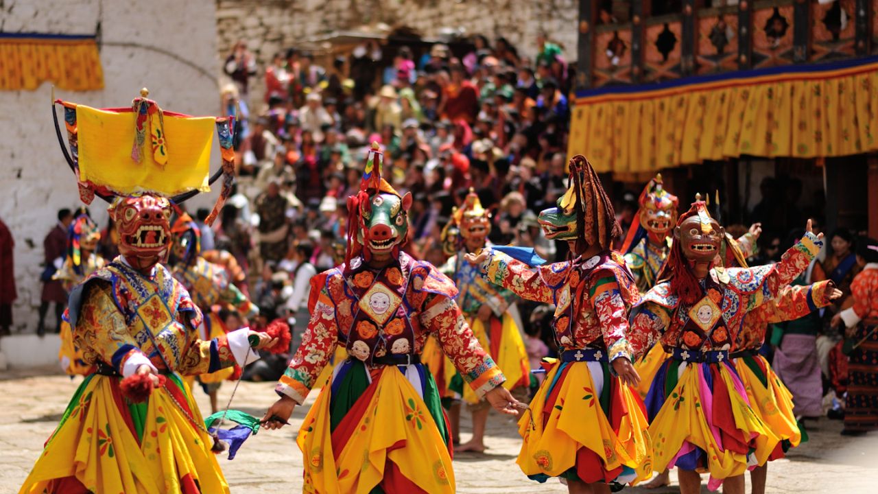 Paro Tshechu festival with traditional masked dances and locals in traditional dress.