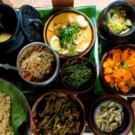 A spread of traditional Bhutanese dishes served in bowls and on banana leaves